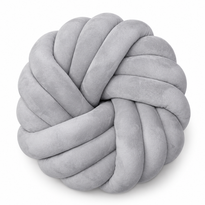 A round, knot-style plush throw pillow in a light gray velvet or microfiber fabric, shown on a clean white background.