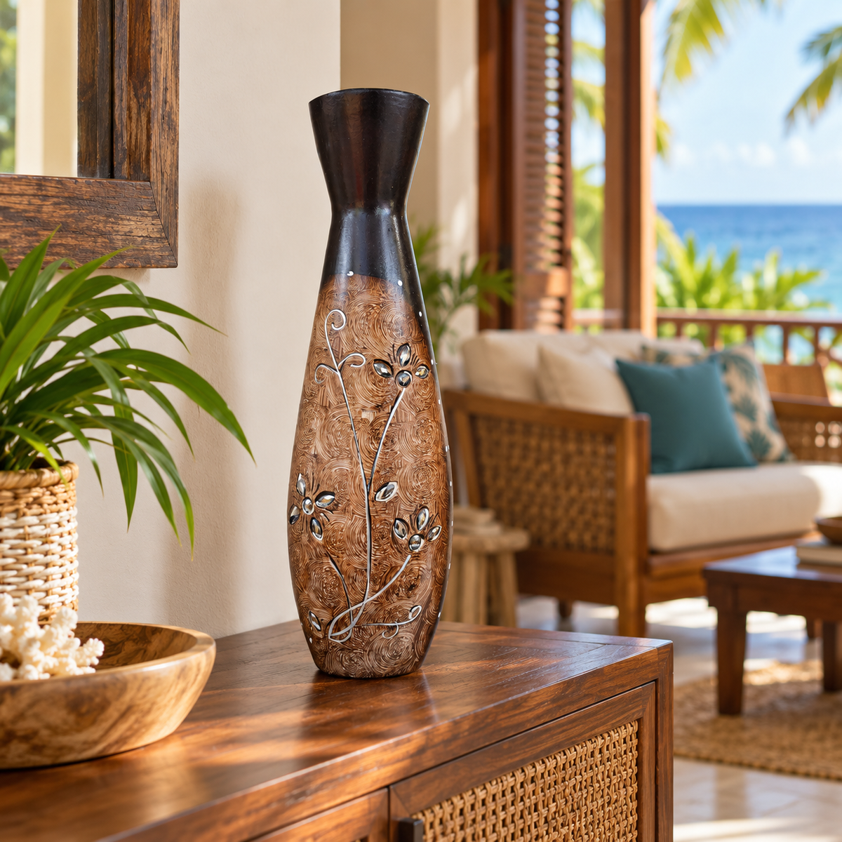 A tall decorative vase with a brown marbled body, dark brown top, and silver floral vine patterns, displayed on a wooden console table in a tropical lounge setting.