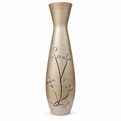 A tall, flared ceramic vase in a warm champagne beige color, decorated with black swirling vine patterns and small silver-toned leaf accents, shown against a plain white background.